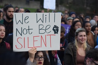 A student holds a sign that reads 