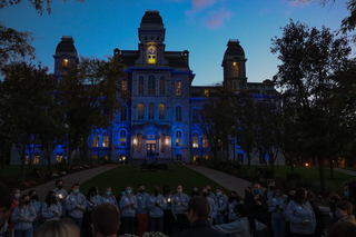 The Remembrance Scholars and vigil attendees gather at the Remembrance Wall for a moment of silence in honor of the tragedy.