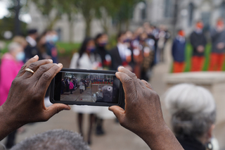 Members of the crowd film the Remembrance Scholars as they proceed from the Hall of Languages to the Place of Remembrance.